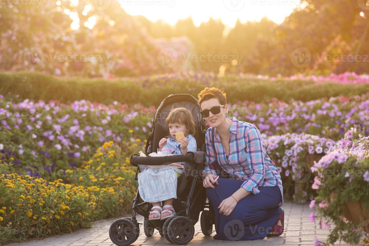 mother and daughter in flower garden photo