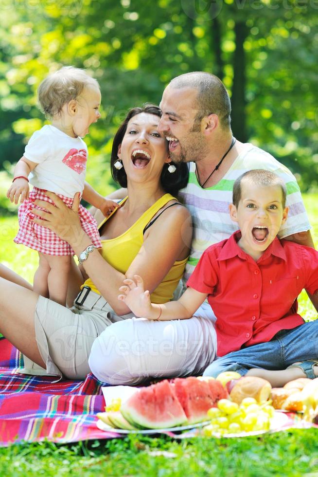 Feliz pareja joven con sus hijos divertirse en el parque foto