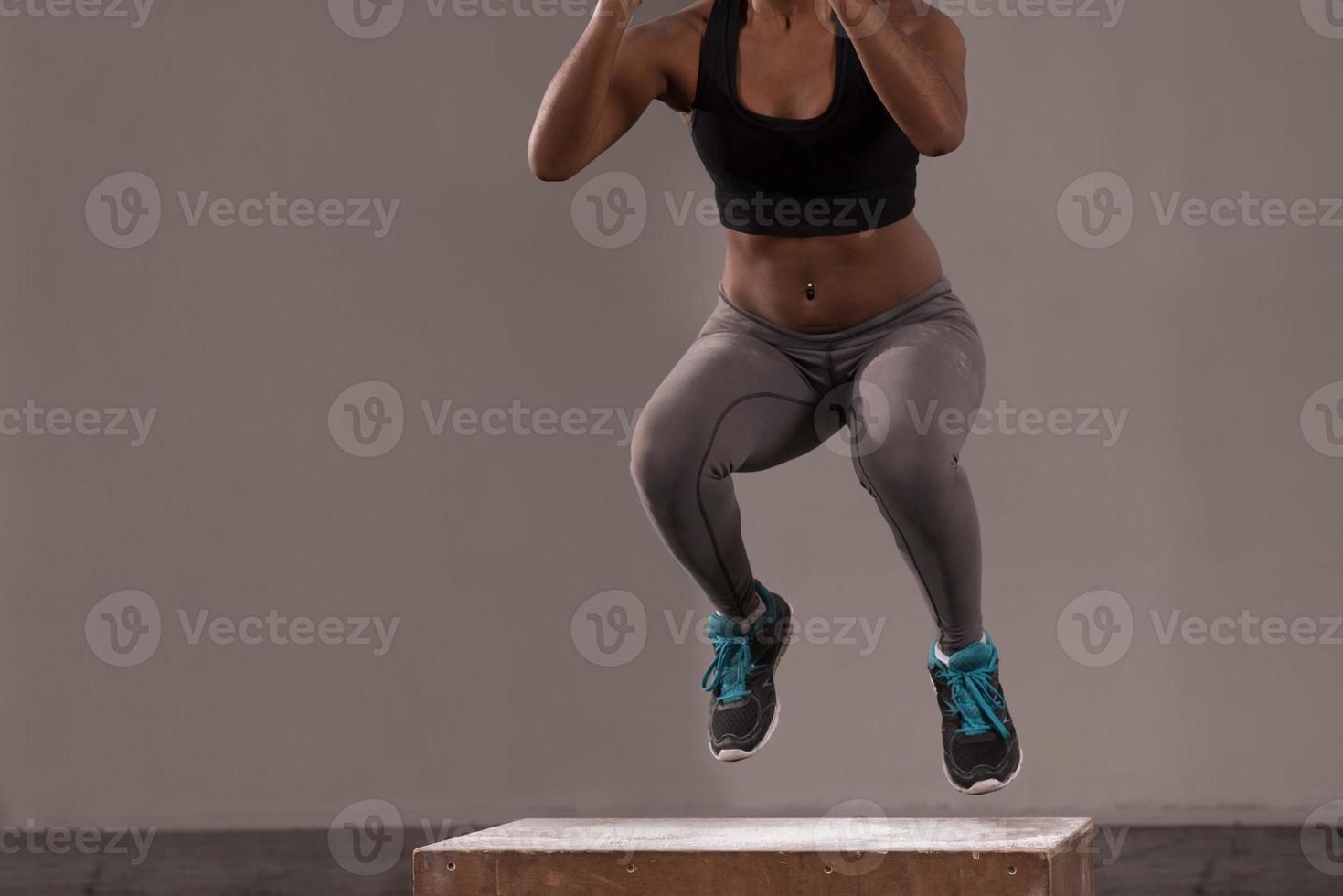 mujer negra está realizando saltos de caja en el gimnasio foto
