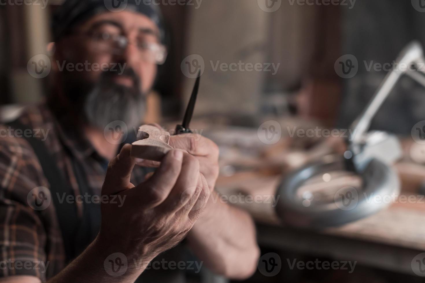 Spoon master in his workshop with wooden products and tools photo