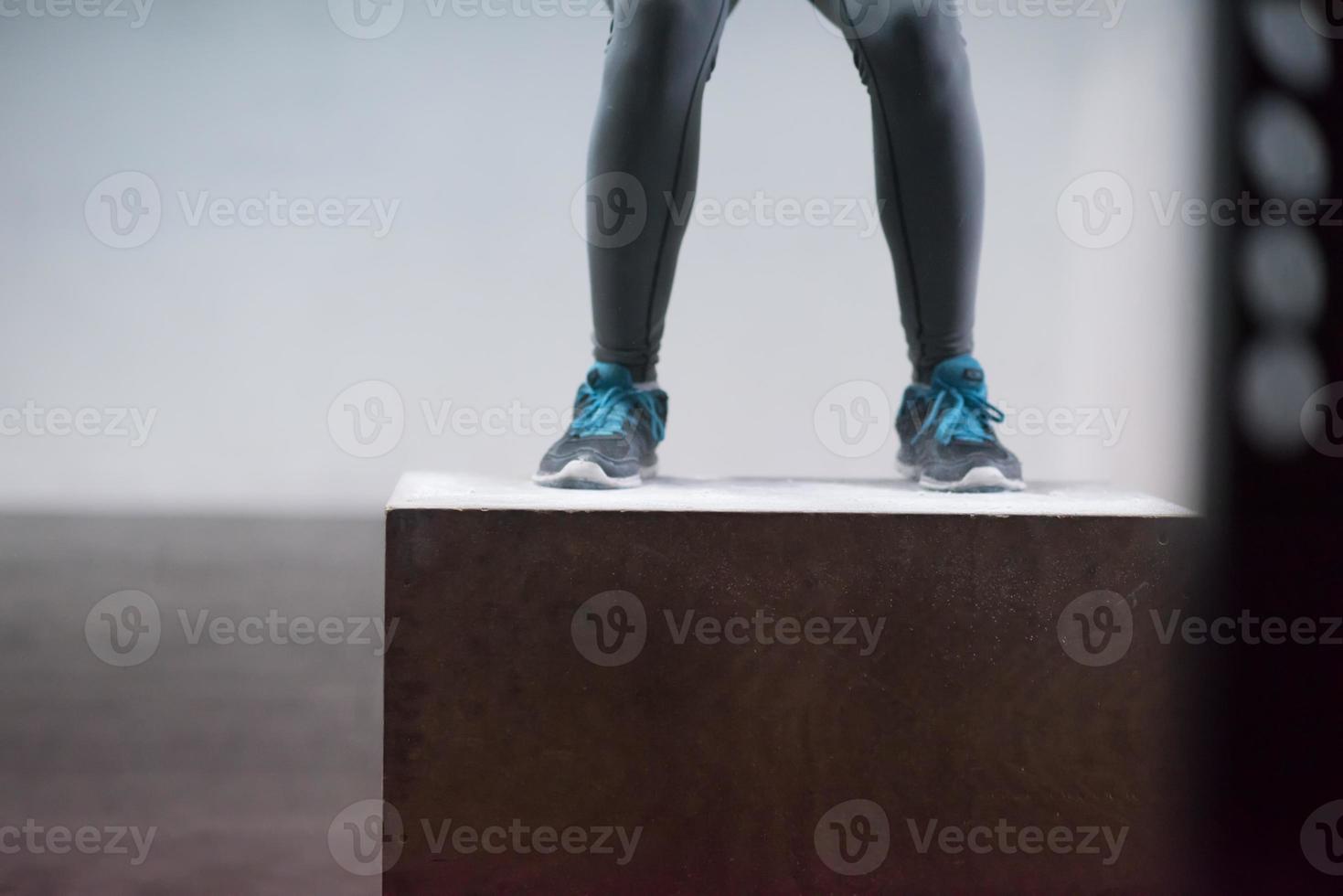 black woman is performing box jumps at gym photo