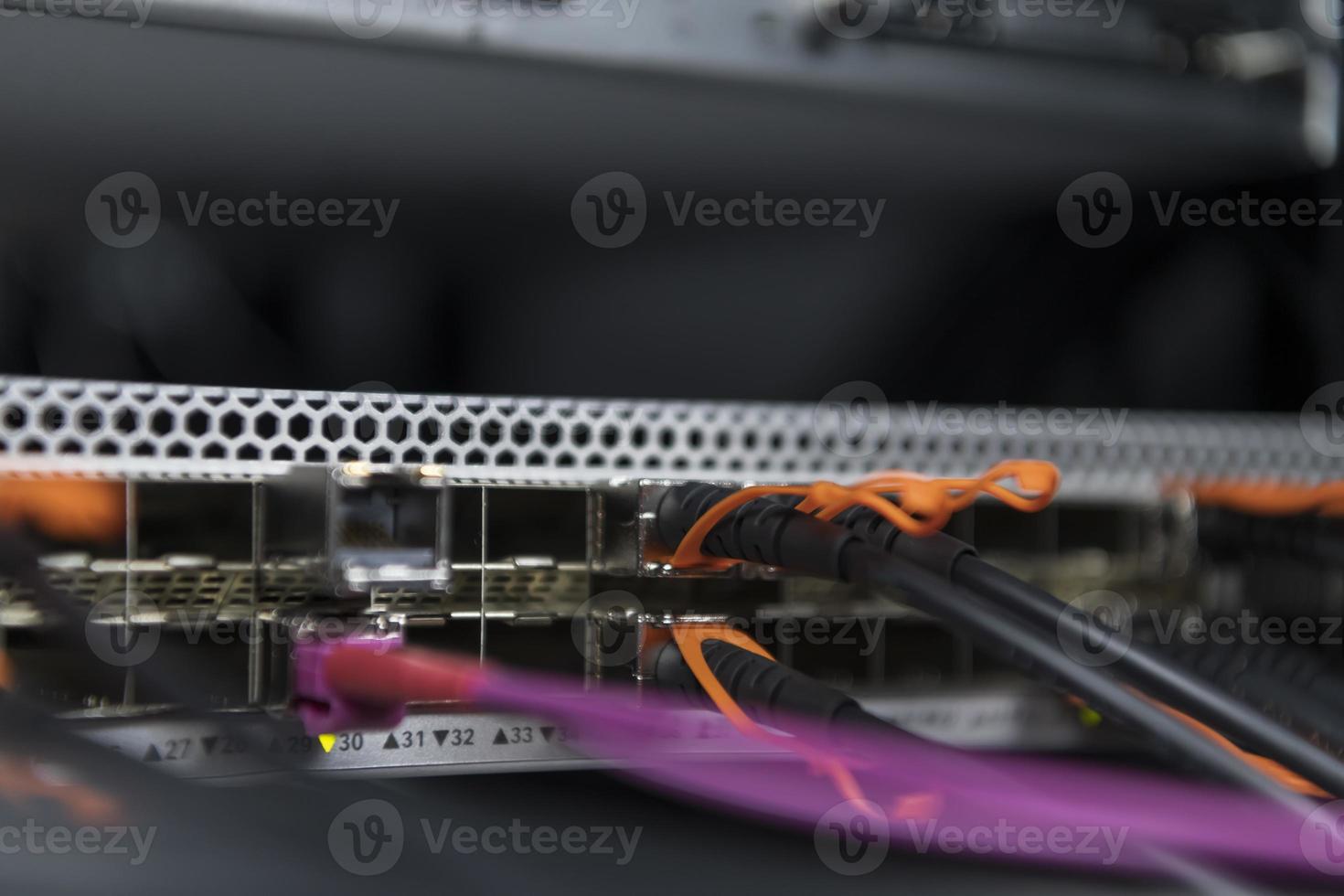 network server room closeup on fiber optic hub or switch for digital communications and internet in mainframe corporate business data center supercomputer. photo