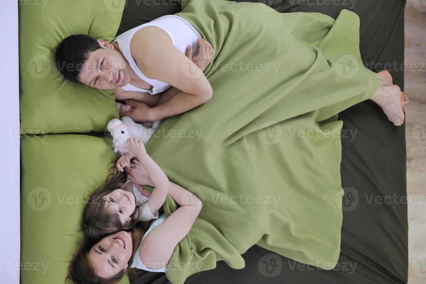 happy family relaxing in bed photo