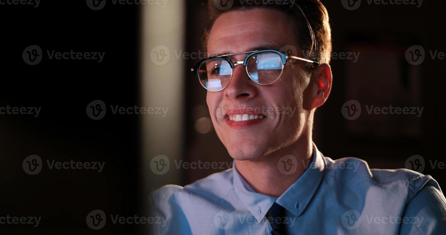 man working on computer in dark office photo