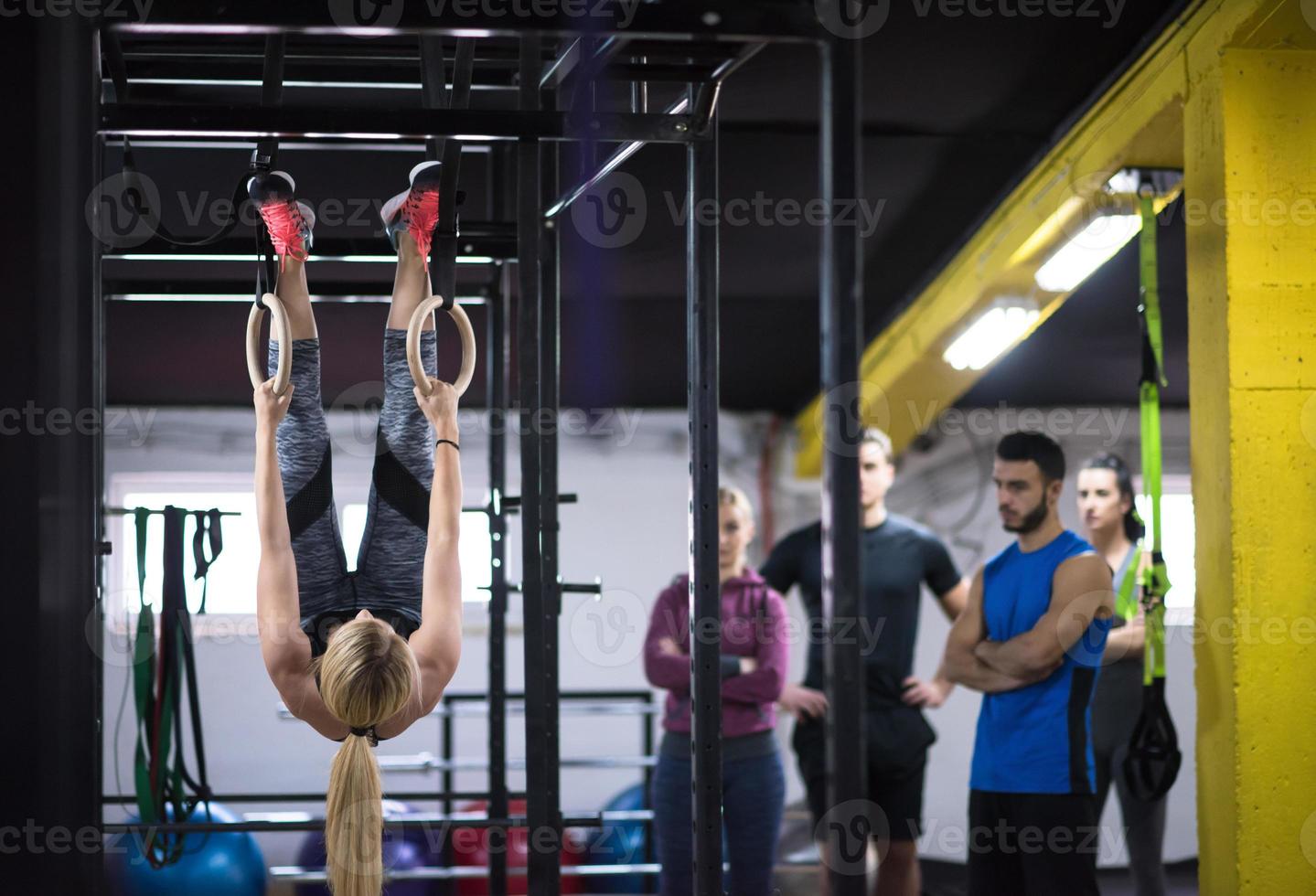 mujer trabajando con entrenador personal en anillos de gimnasia foto