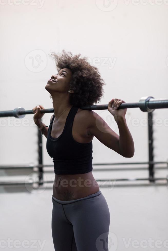 black woman lifting empty bar photo