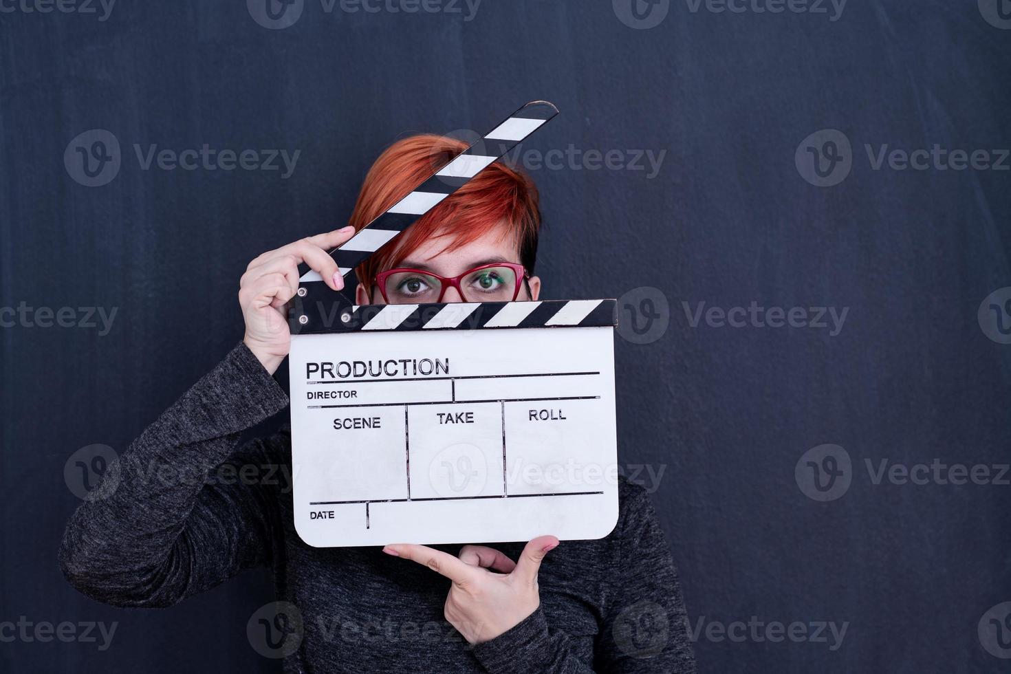 redhead woman holding movie clapper photo