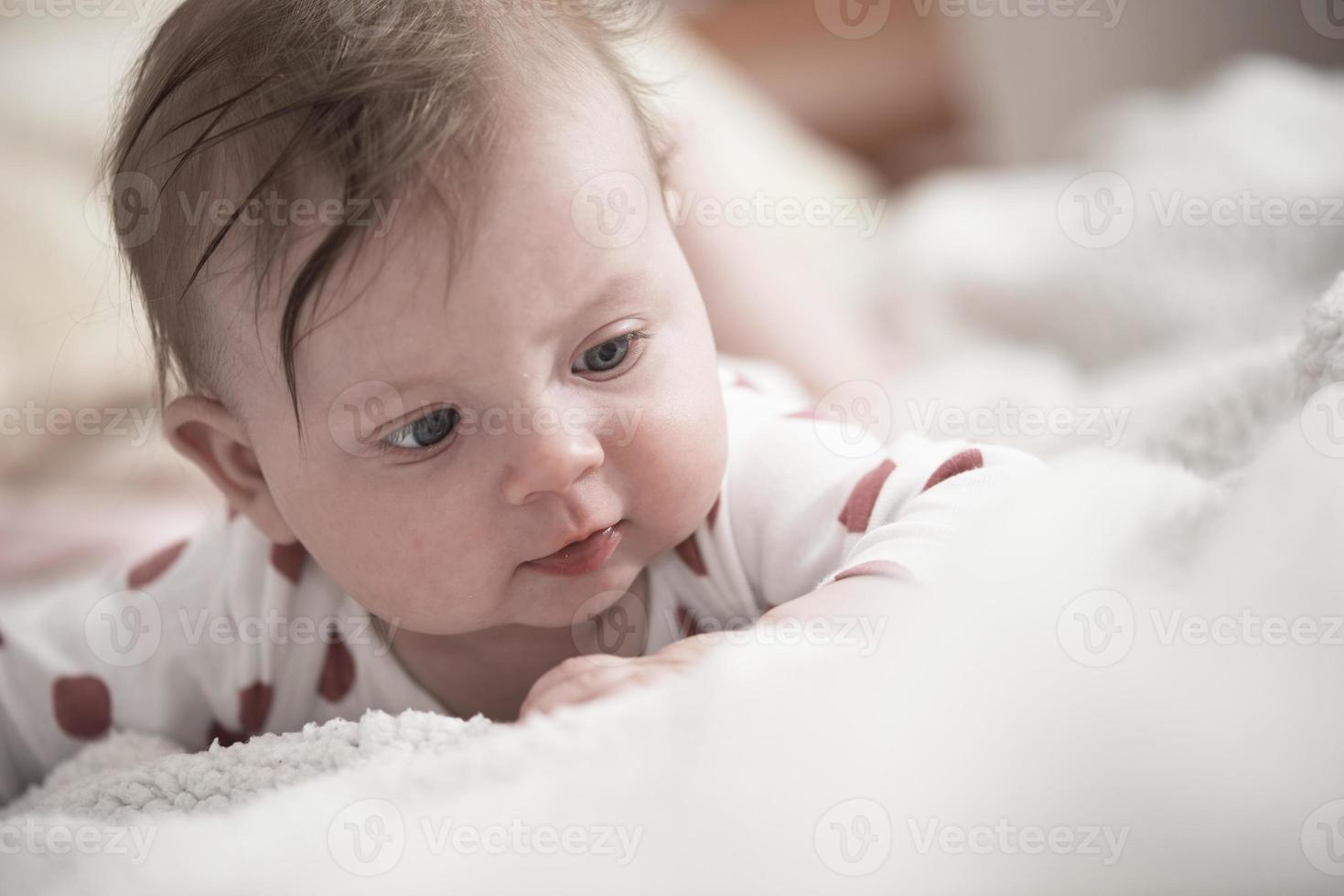 cute little baby playing with hands and smiling photo