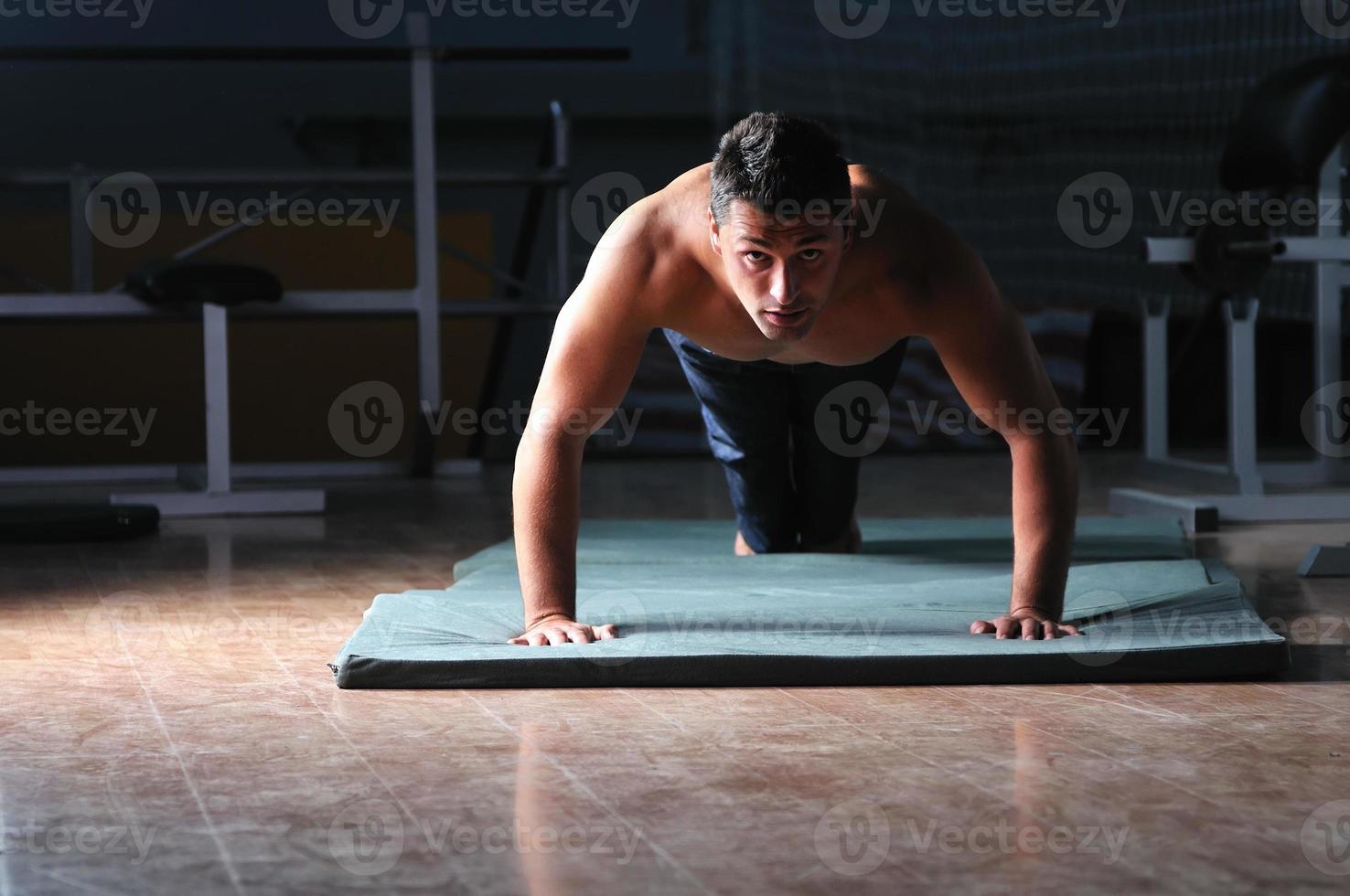 young man with strong arms working out in gym photo