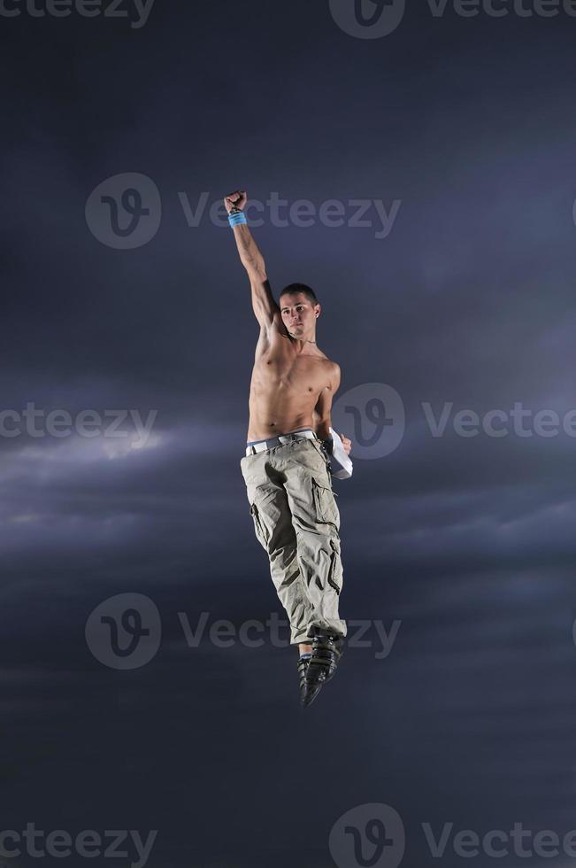 young man dancing and jumping  on top of the building photo
