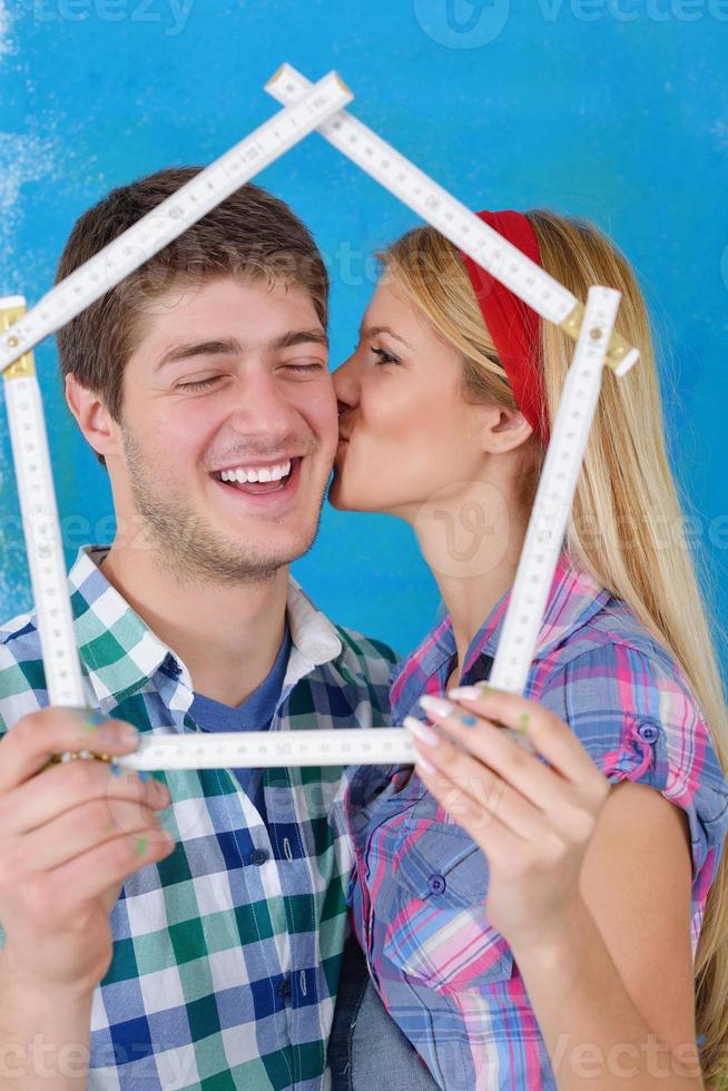 pareja feliz pintando una pared en su nuevo hogar foto