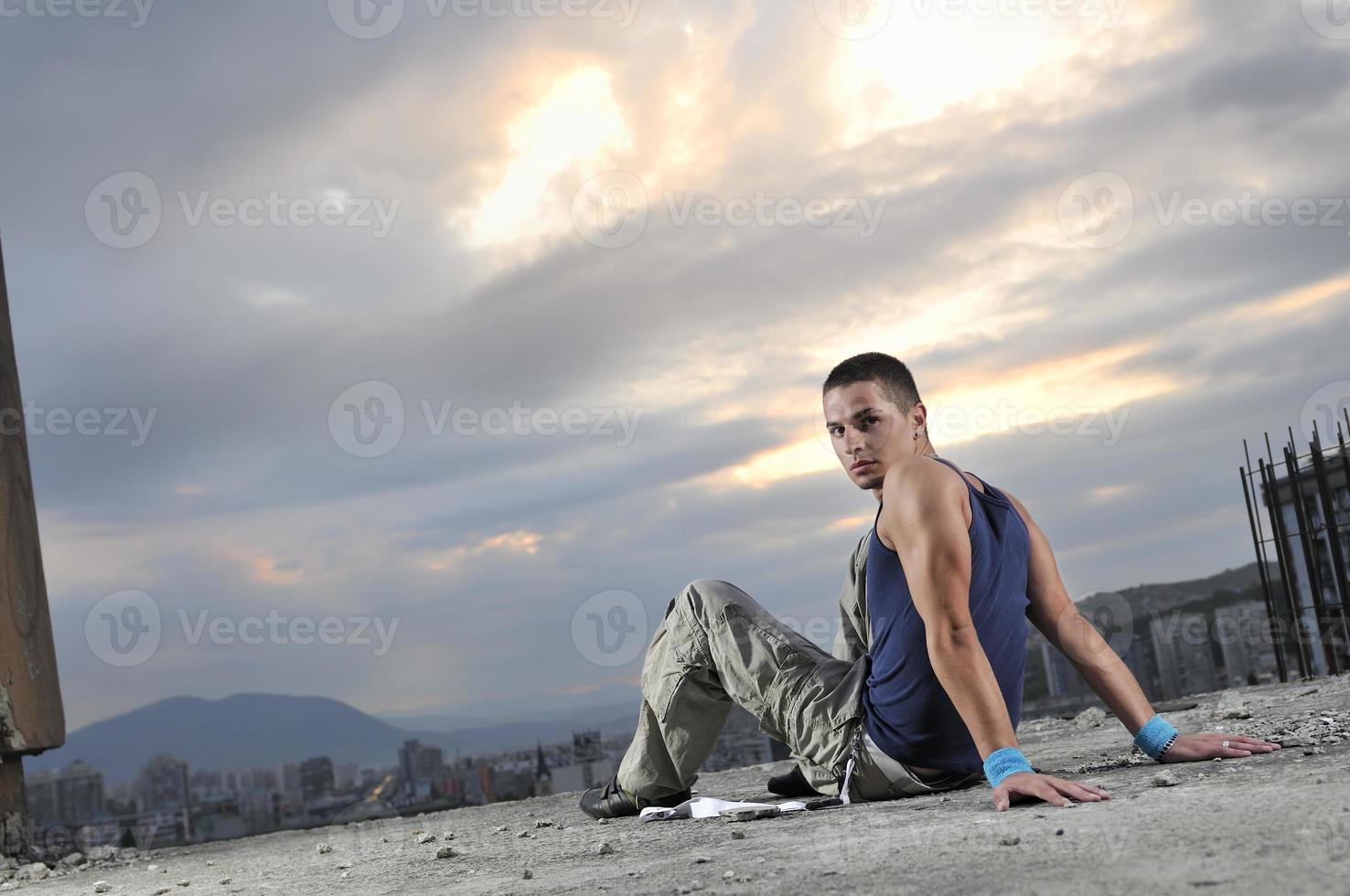 young man dancing and jumping  on top of the building photo