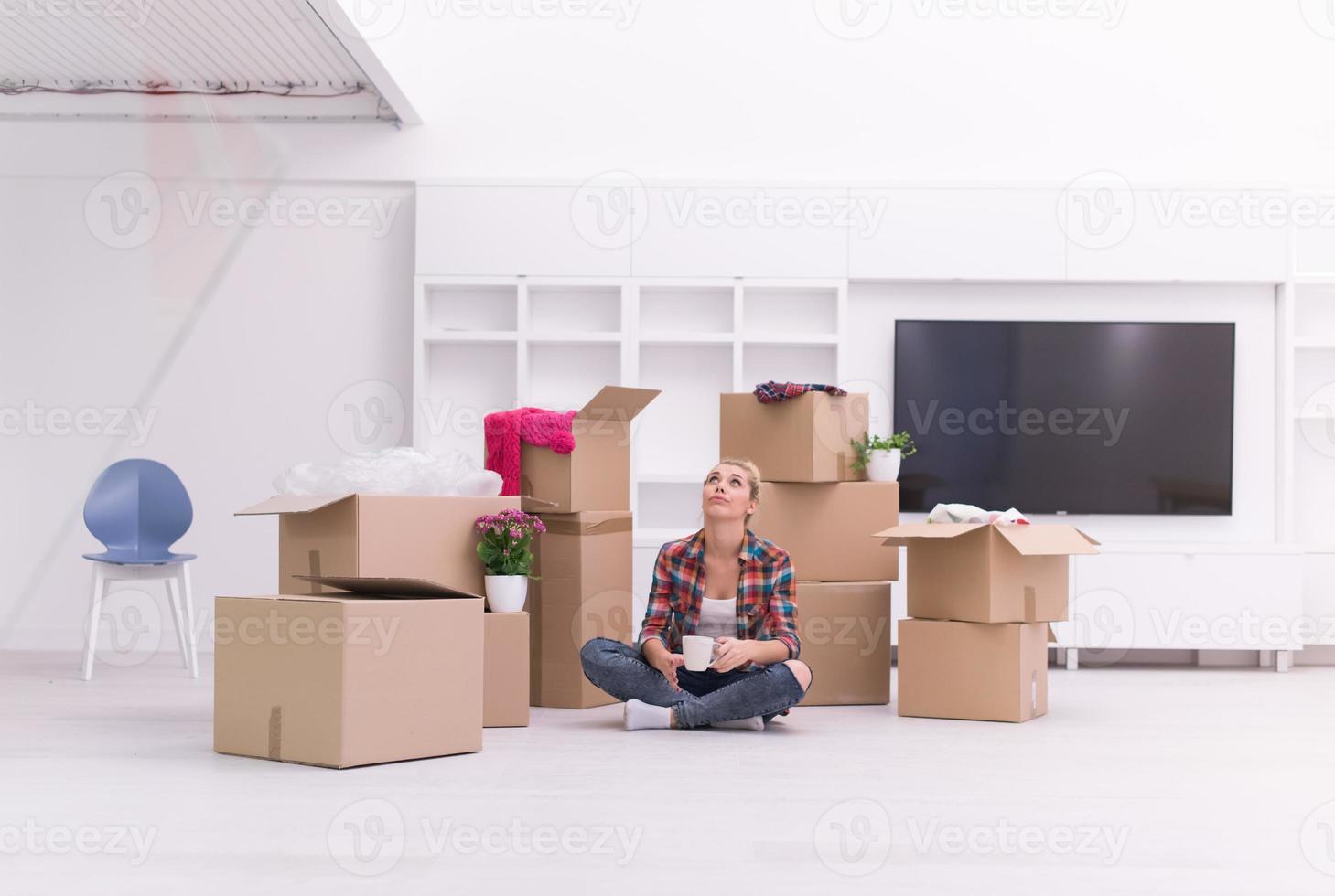 woman with many cardboard boxes sitting on floor photo