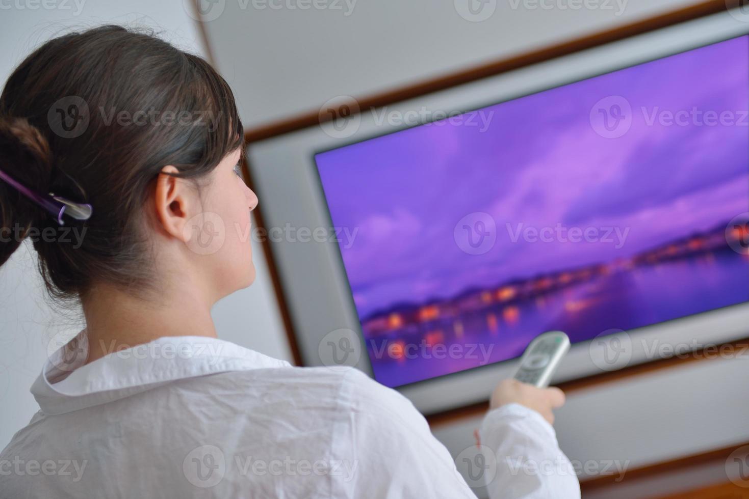 young woman watching tv at home photo