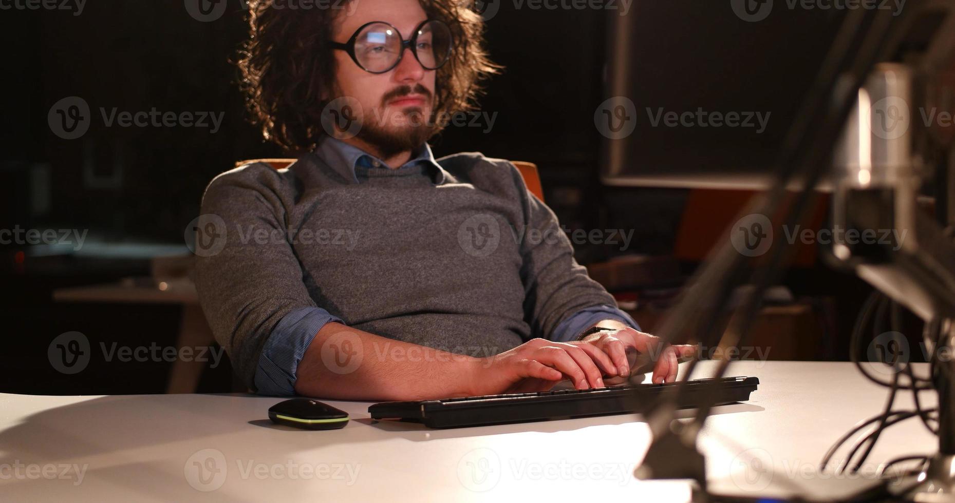 hombre trabajando en una computadora en una oficina oscura foto