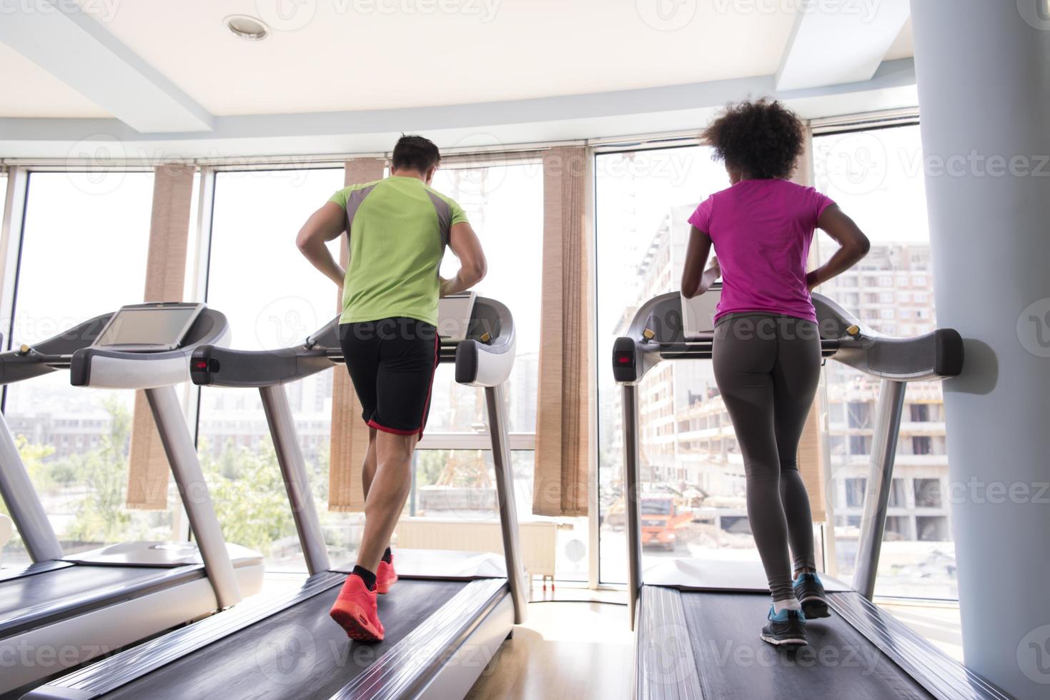 people exercisinng a cardio on treadmill in gym photo