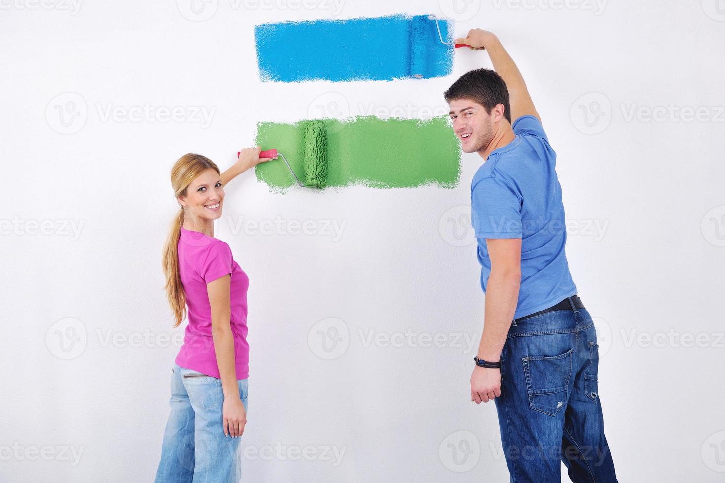 happy couple paint wall at new home photo