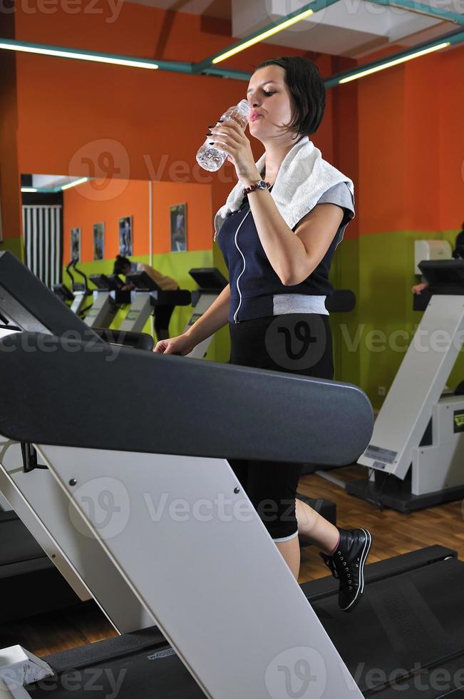 Young woman drinking water while working out photo