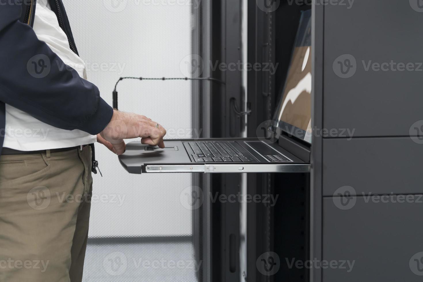 Close up on Data Center Engineer hands Using keyboard on a supercomputer Server Room Specialist Facility with Male System Administrator Working with Data Protection Network for Cyber Security. photo