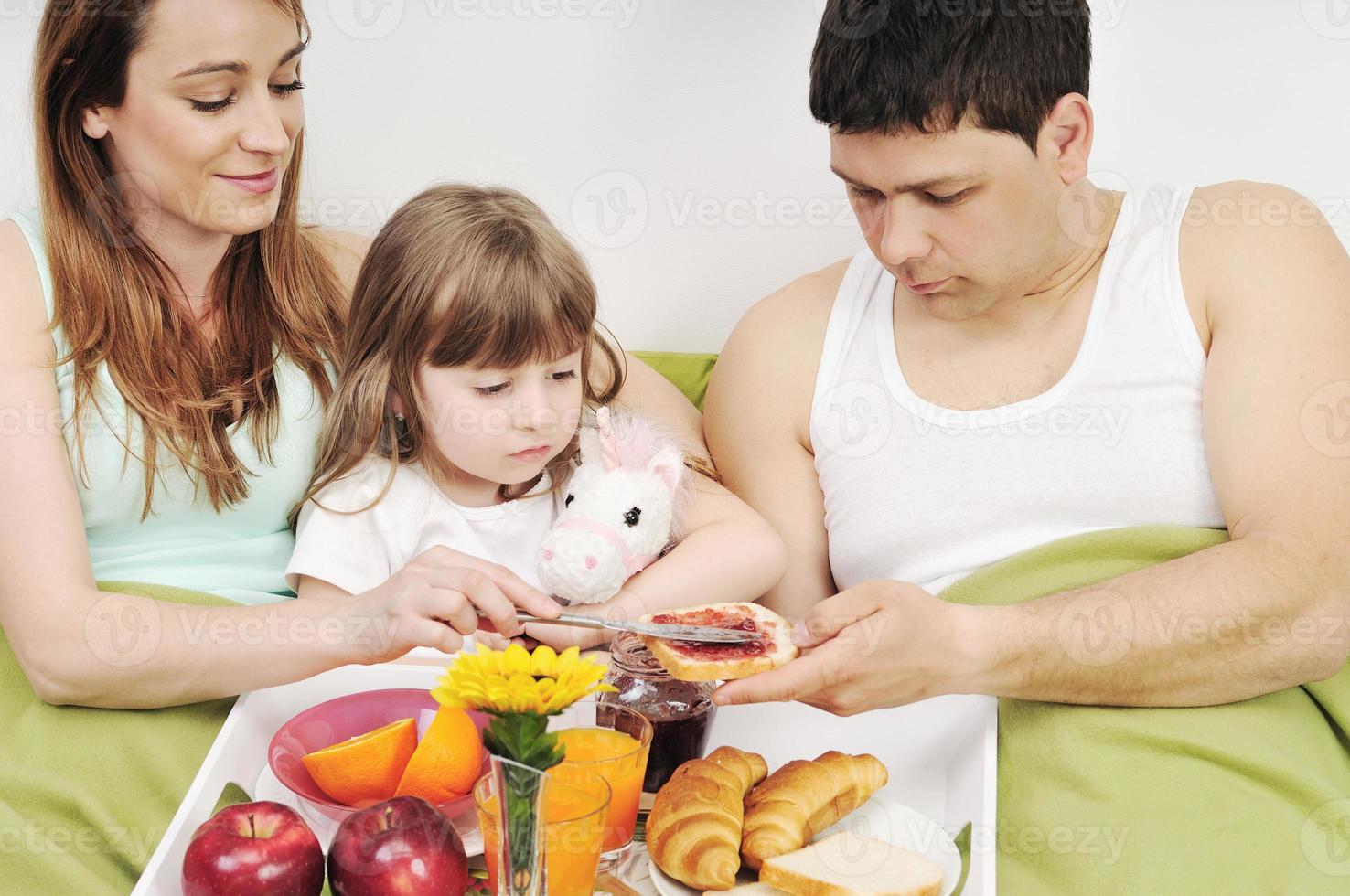 happy young family eat breakfast in bed photo