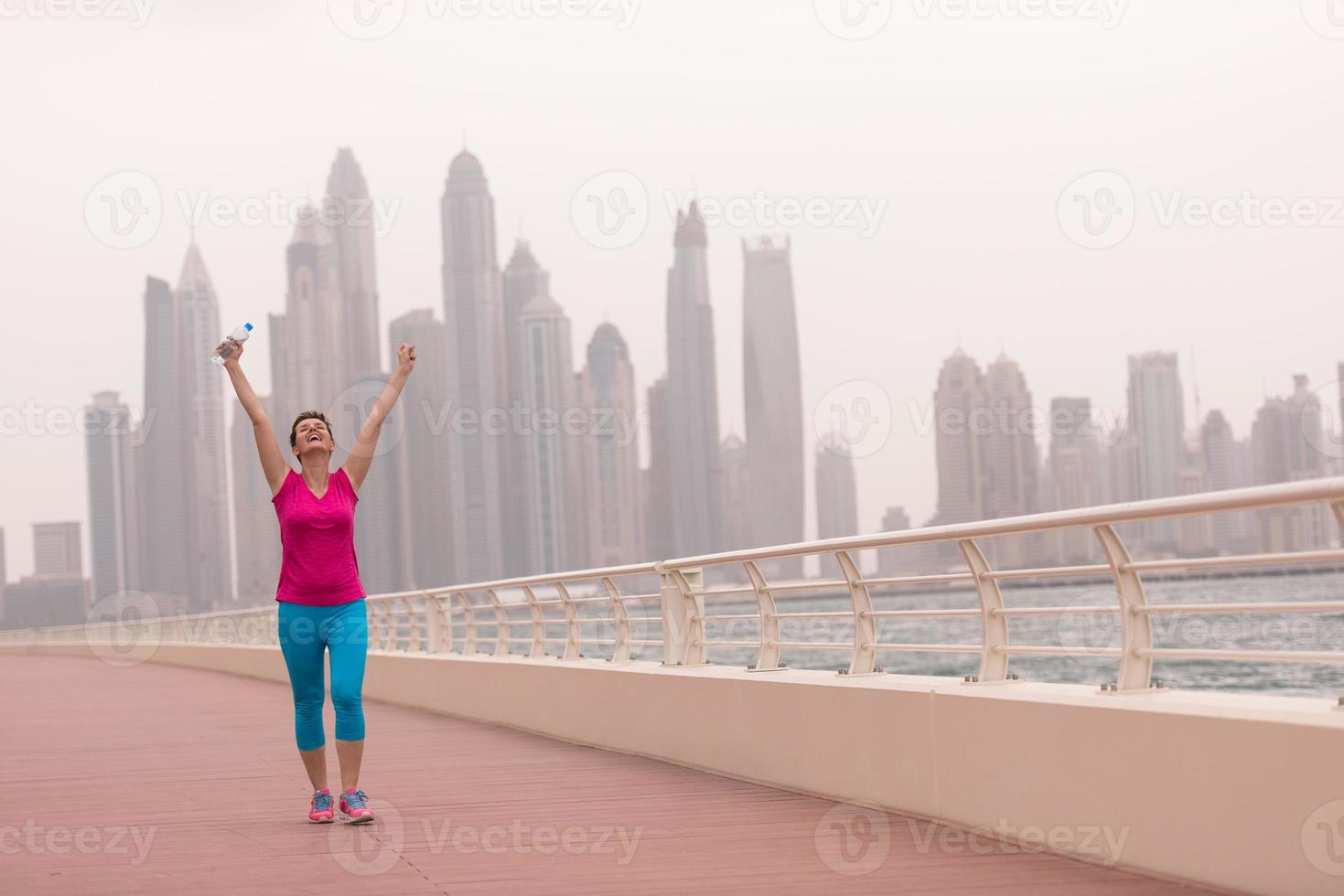 mujer joven celebrando una carrera de entrenamiento exitosa foto