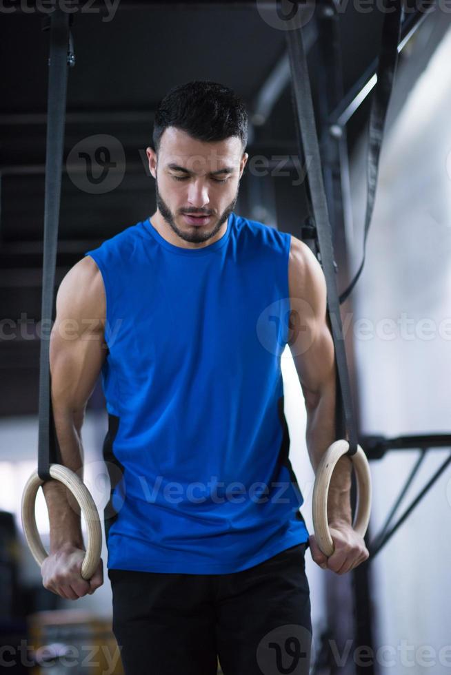 man working out pull ups with gymnastic rings photo