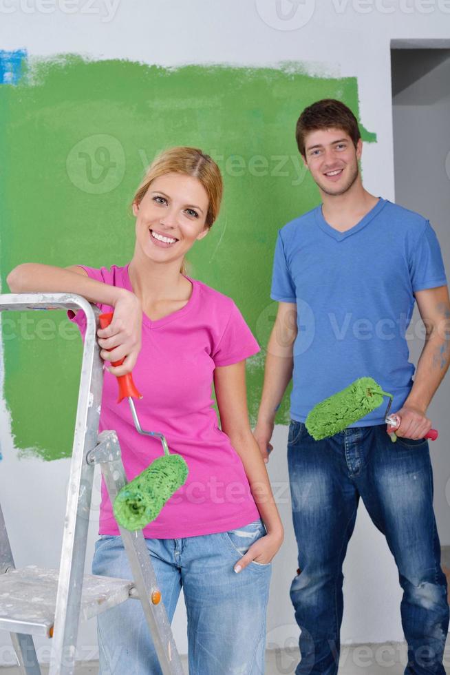 happy couple paint wall at new home photo