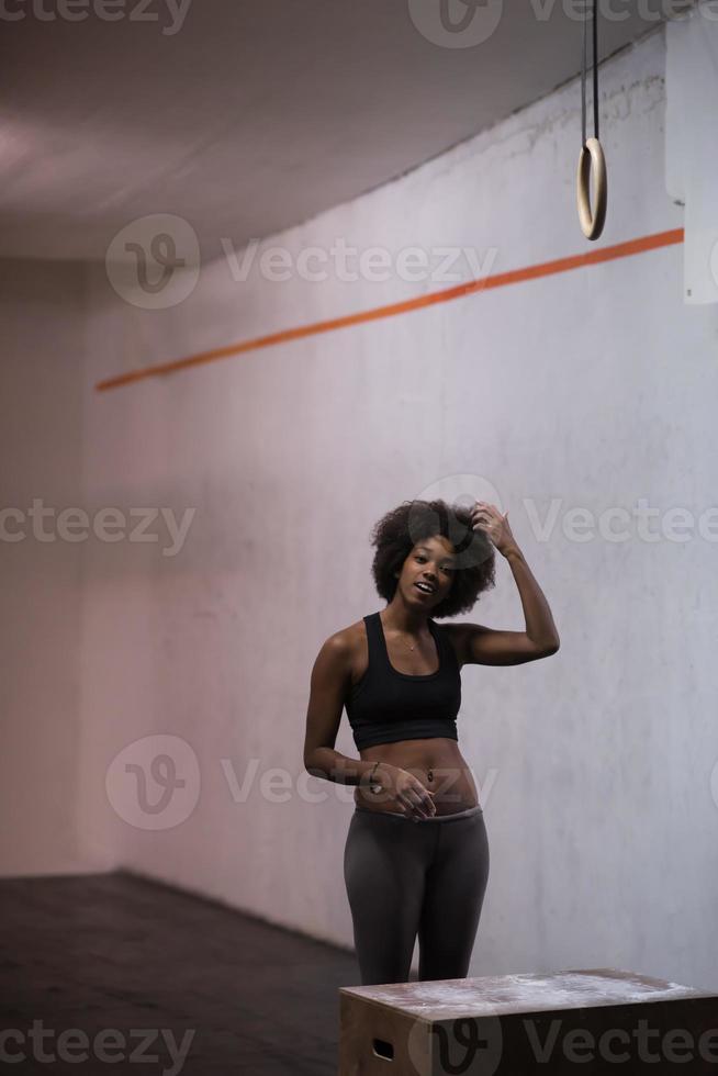 atleta femenina negra está realizando saltos de caja en el gimnasio foto