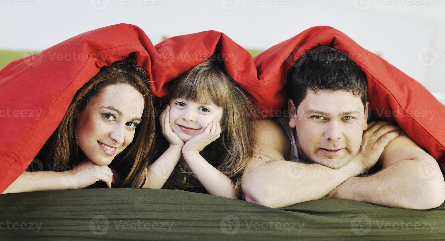 happy family relaxing in bed photo