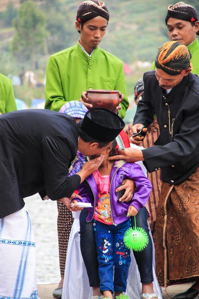 Dieng, Indonesia - August 1, 2015. Dieng Culture Festival, Tourists follow the dreadlocks procession during the Dieng Culture Festival event at Dieng, Banjarnegara district, Central Java photo