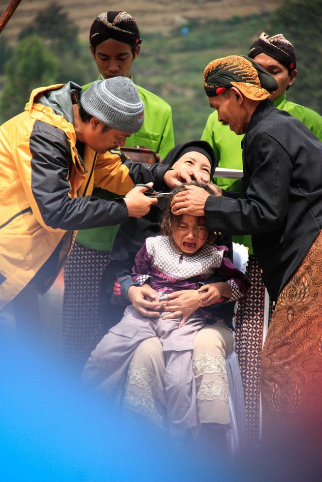 Dieng, Indonesia - August 1, 2015. Dieng Culture Festival, Tourists follow the dreadlocks procession during the Dieng Culture Festival event at Dieng, Banjarnegara district, Central Java photo