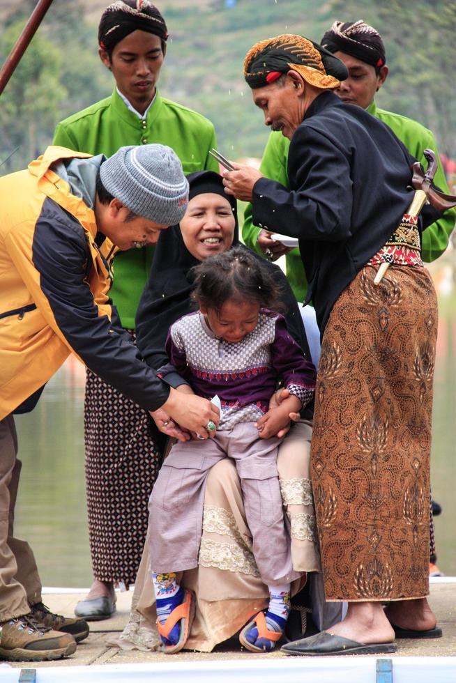 Dieng, Indonesia - August 1, 2015. Dieng Culture Festival, Tourists follow the dreadlocks procession during the Dieng Culture Festival event at Dieng, Banjarnegara district, Central Java photo