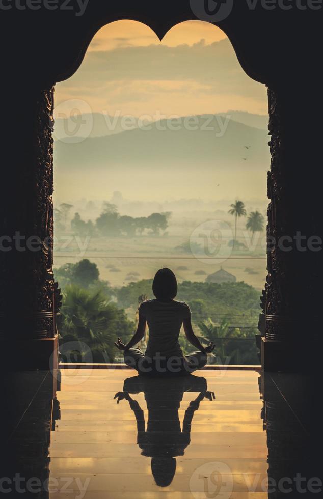 Silhouette of a beautiful Yoga woman in the morning - vintage style color effect photo