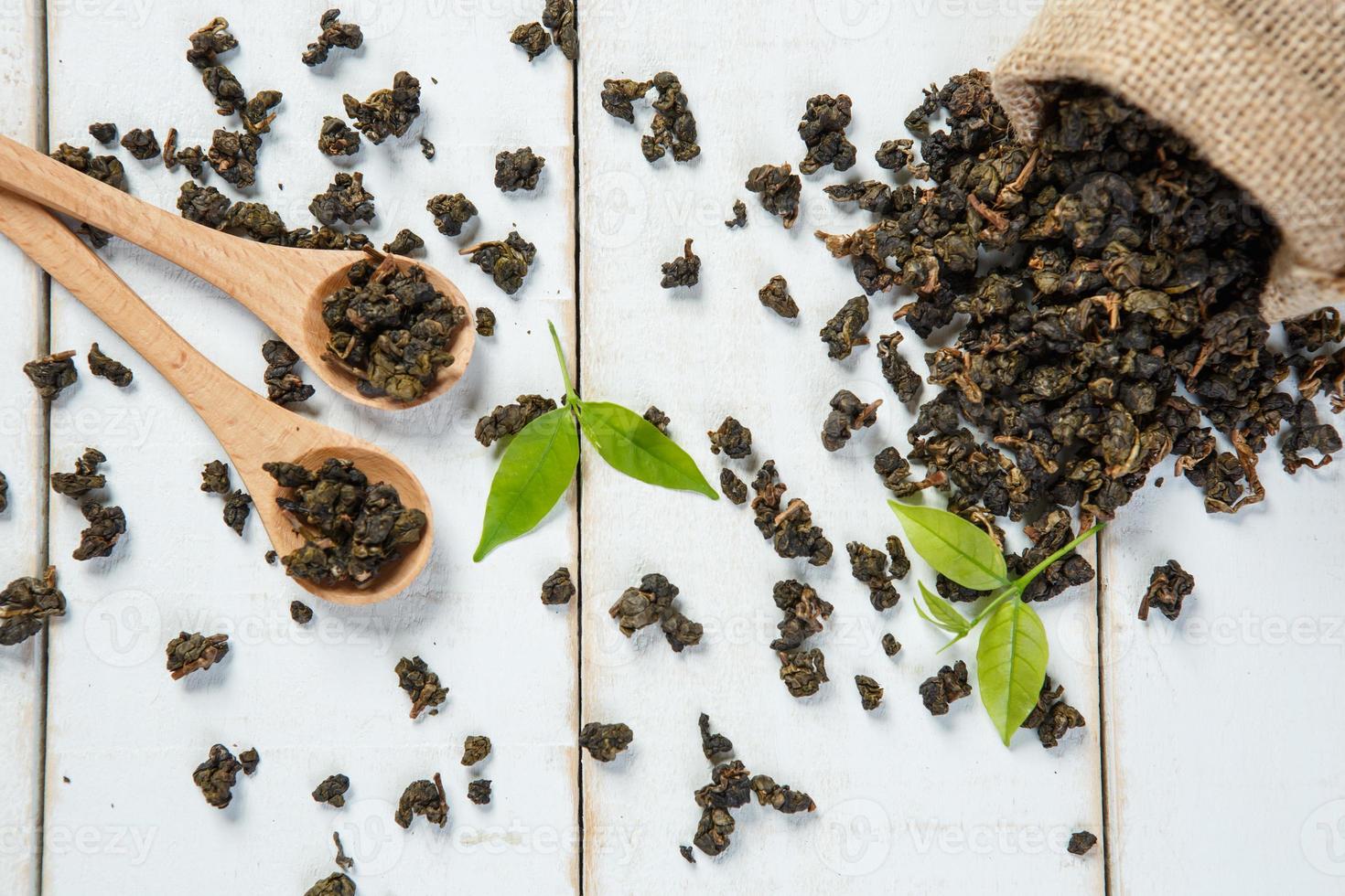 té seco con cuchara de madera y tela de saco en madera blanca foto