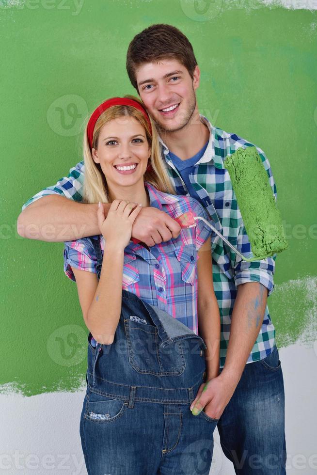 happy couple paint wall at new home photo