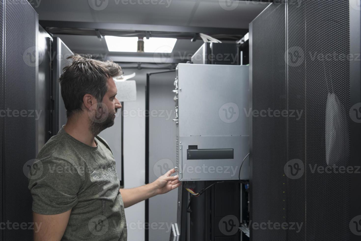 IT engineer working In the server room or data center The technician puts in a rack a new server of corporate business mainframe supercomputer or cryptocurrency mining farm. photo