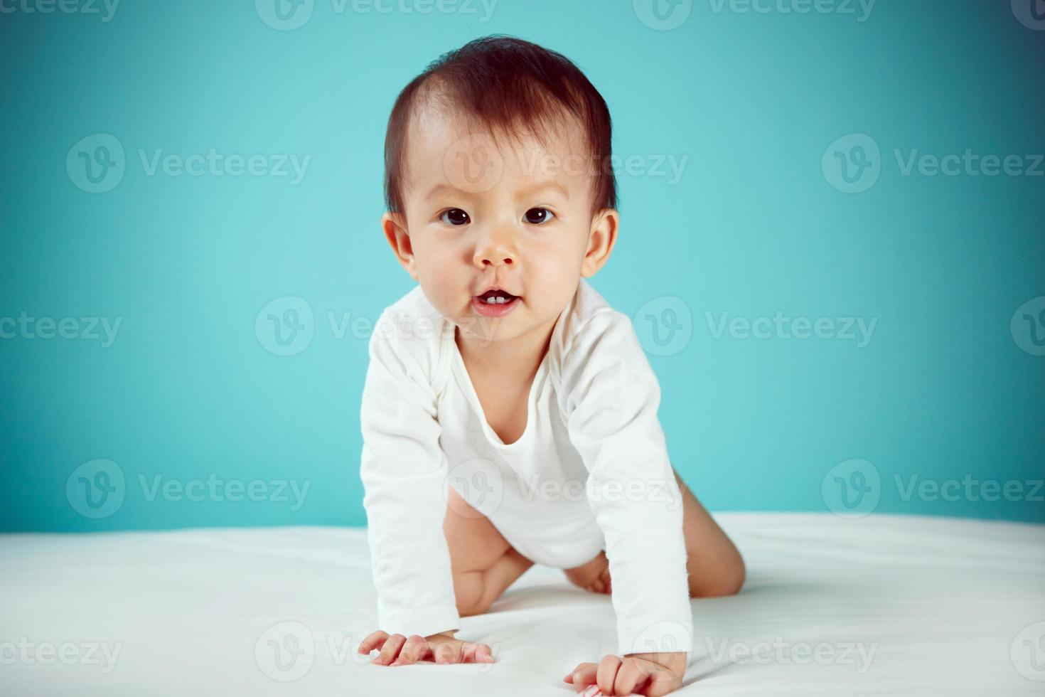 A crawling newborn in diaper with blue background photo