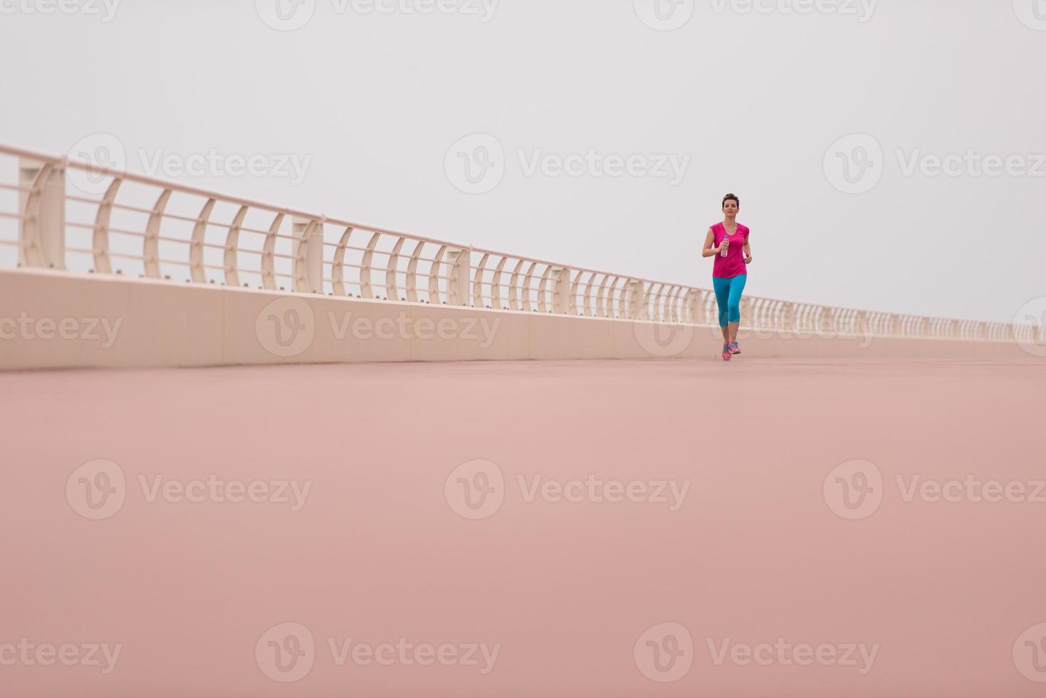 mujer ocupada corriendo en el paseo marítimo foto