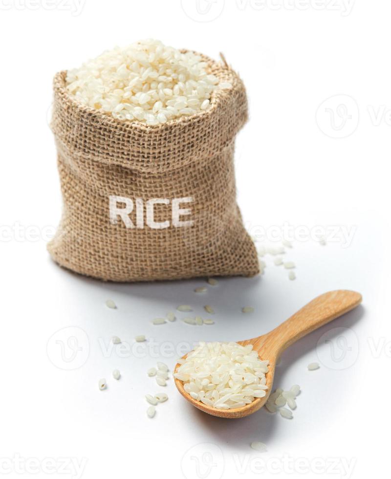 Dry rice with spoon grains in burlap photo