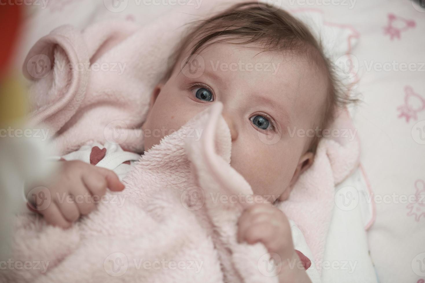 cute little baby playing with hands and smiling photo