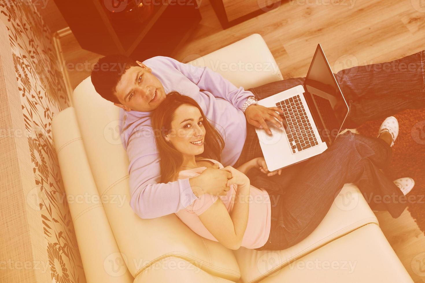 young couple working on laptop at home photo