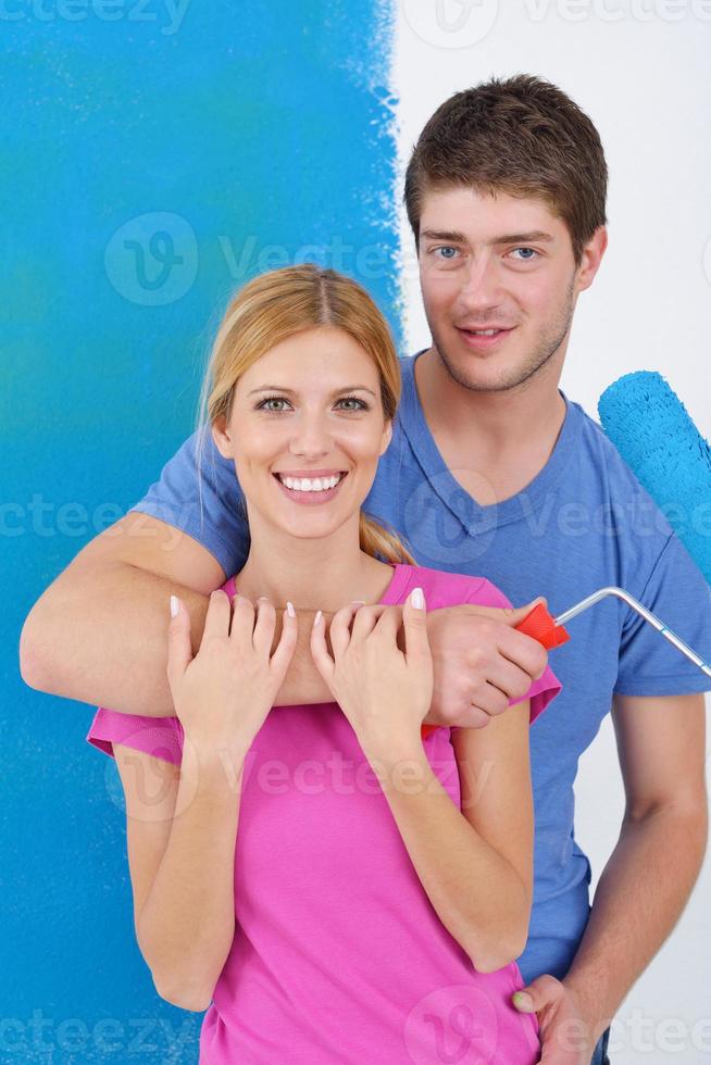 happy couple paint wall at new home photo