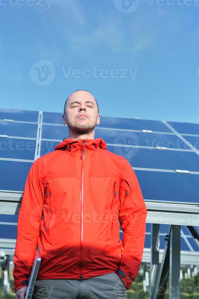 ingeniero que usa una computadora portátil en el campo de la planta de paneles solares foto