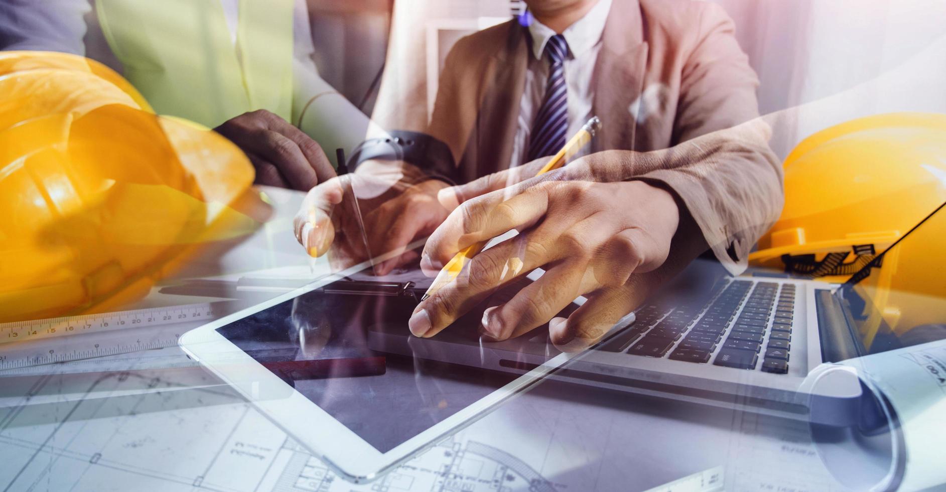 business hand working and laptop with on on architectural project at construction site at office desk in office photo