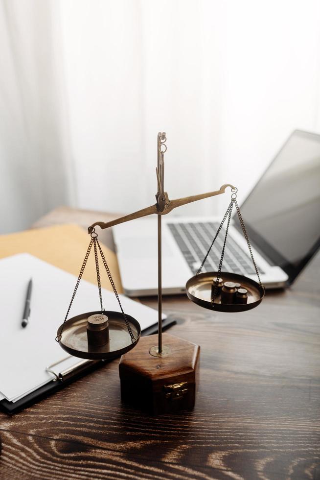 Business and lawyers discussing contract papers with brass scale on desk in office. Law, legal services, advice, justice and law concept picture with film grain effect photo