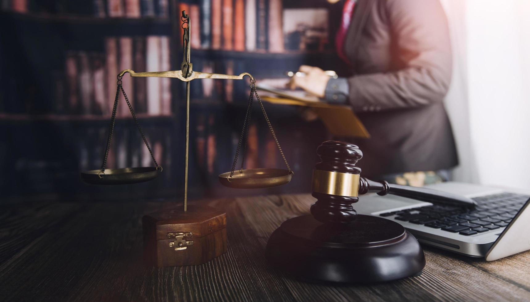 Business and lawyers discussing contract papers with brass scale on desk in office. Law, legal services, advice, justice and law concept picture with film grain effect photo