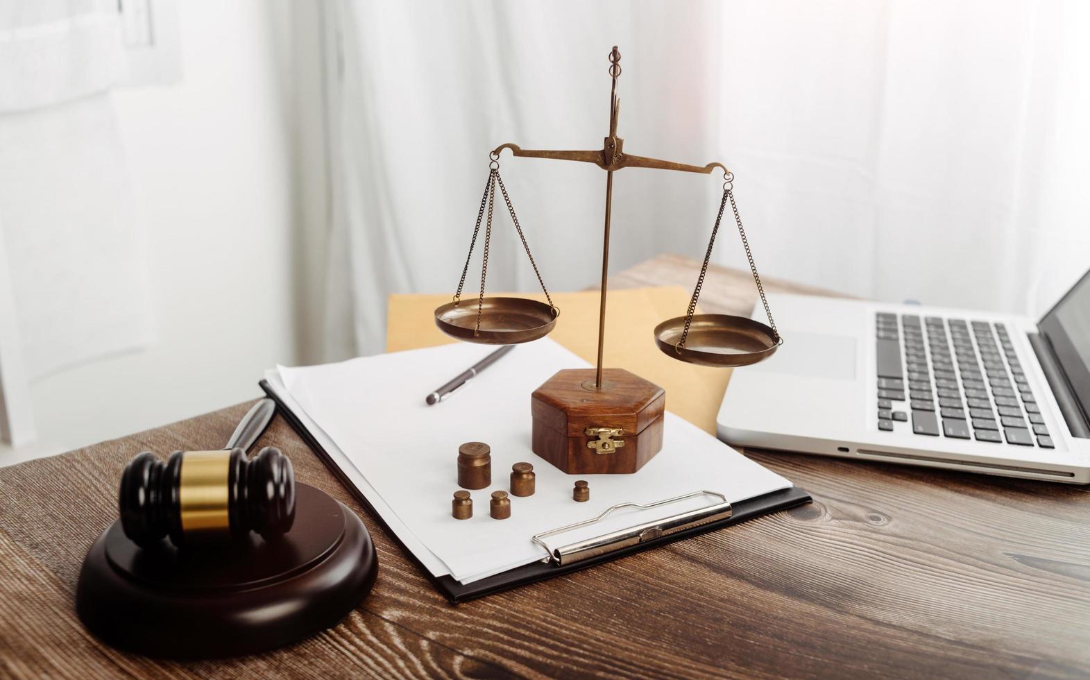 Business and lawyers discussing contract papers with brass scale on desk in office. Law, legal services, advice, justice and law concept picture with film grain effect photo