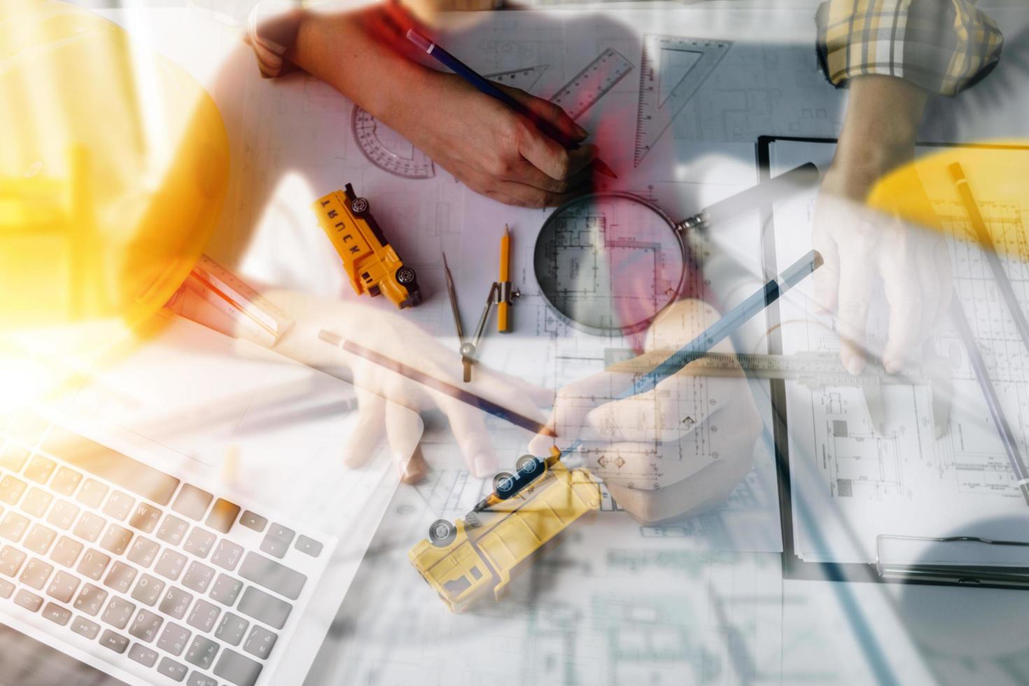 business hand working and laptop with on on architectural project at construction site at office desk in office photo