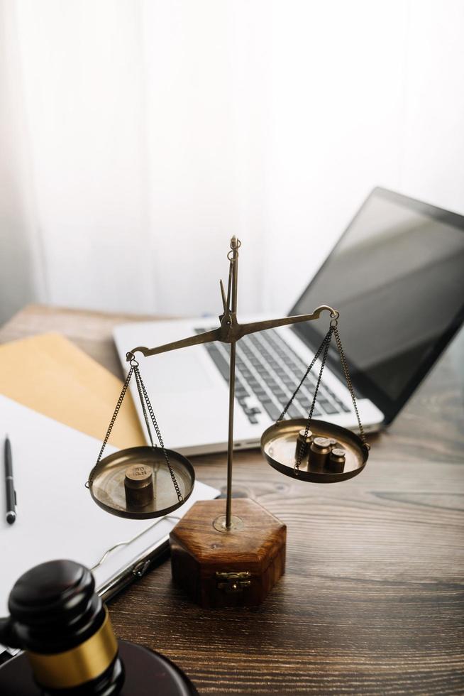 Business and lawyers discussing contract papers with brass scale on desk in office. Law, legal services, advice, justice and law concept picture with film grain effect photo