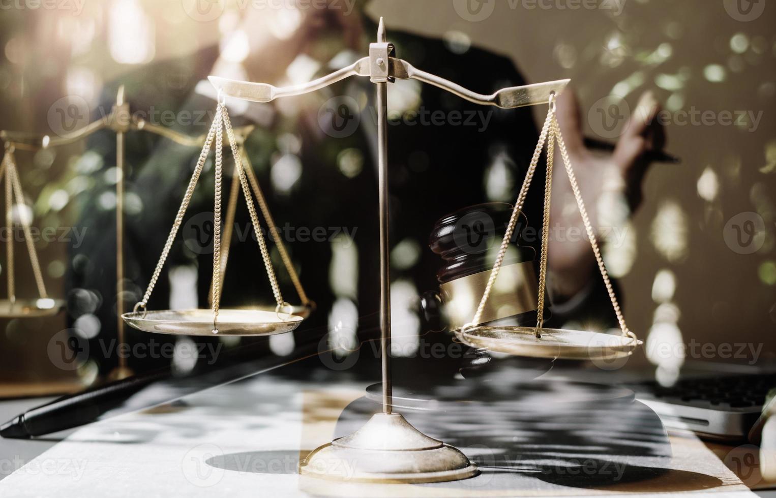Justice and law concept.Male judge in a courtroom with the gavel, working with, computer and docking keyboard, eyeglasses, on table in morning light photo